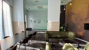 A conference room with a long table, chairs, a sofa, and a ping pong table. - Student Only The View (Newcastle)