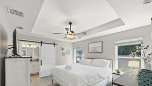 A bedroom with a bed, a ceiling fan, a window, and a view of the outdoors. - Captain`s Quarters - New Listing (Pensacola)