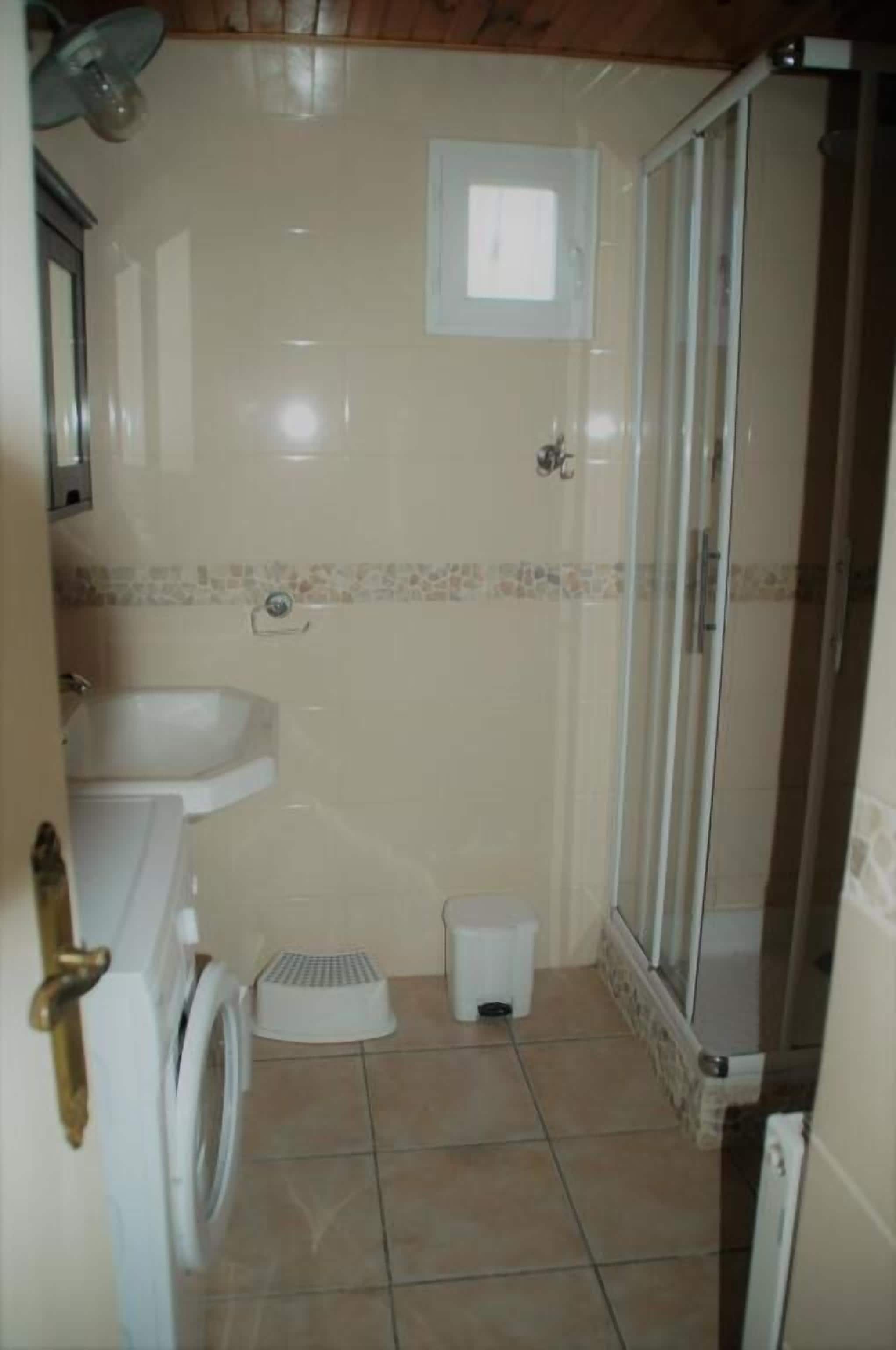 Un baño con ducha, lavamanos e inodoro.