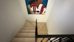 Een trap met een schilderij aan de muur.
