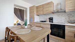 A modern kitchen with wooden cabinets, a built-in oven, and a dining table with placemats.