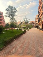 Zona residencial con senderos pavimentados, céspedes verdes y edificios de varios pisos.