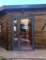 Un edificio de madera con un letrero que dice 'FITNESS' sobre la entrada.