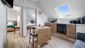 Een modern loft-appartement met keuken, eethoek en een slaapkamer.