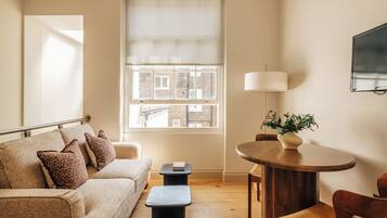 Apartment, 1 Bedroom | Living area | 32-inch flat-screen TV with digital channels