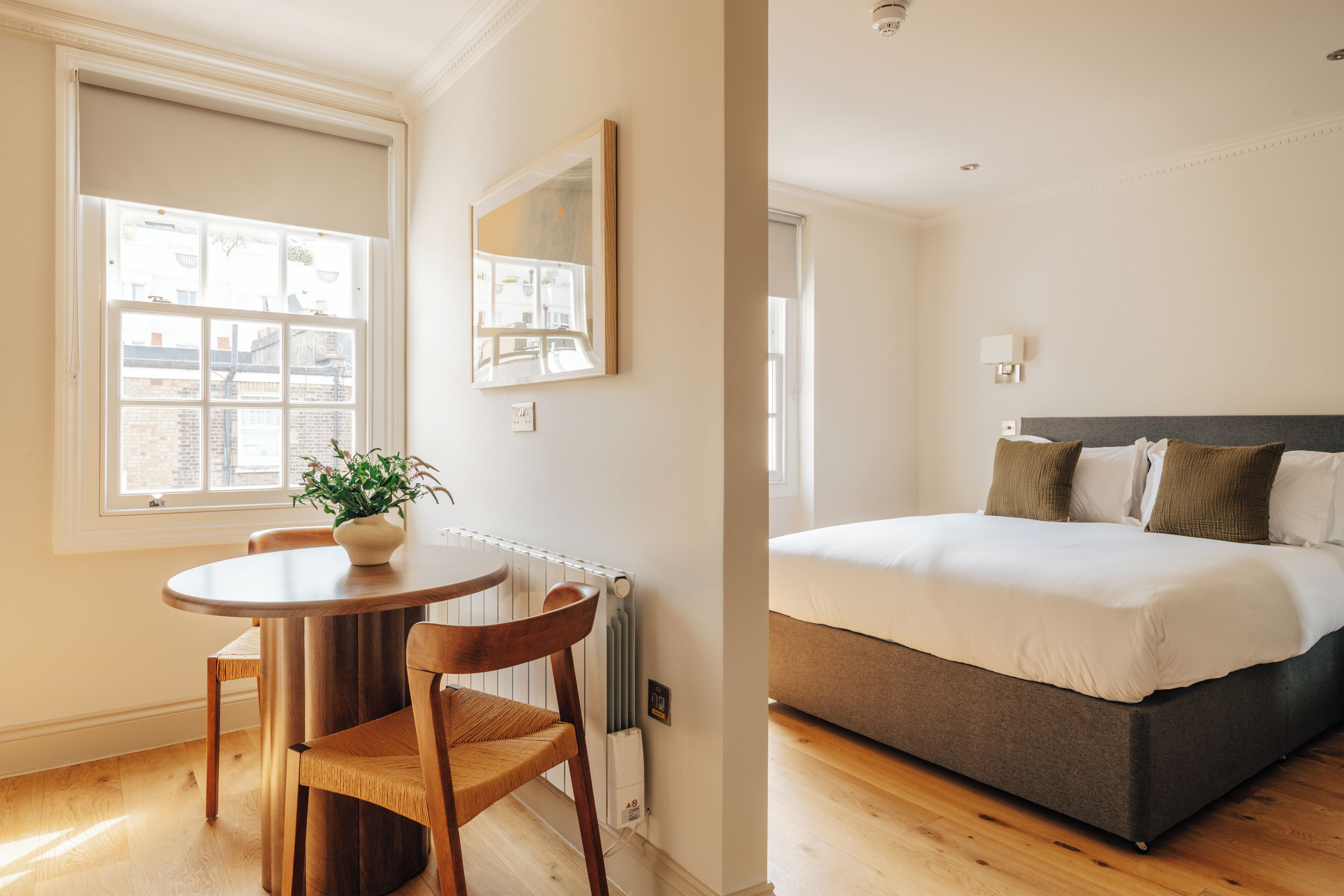 A bedroom with a bed, a bedside table, and a chair.