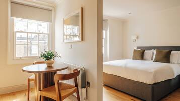 A bedroom with a bed, a bedside table, and a chair.