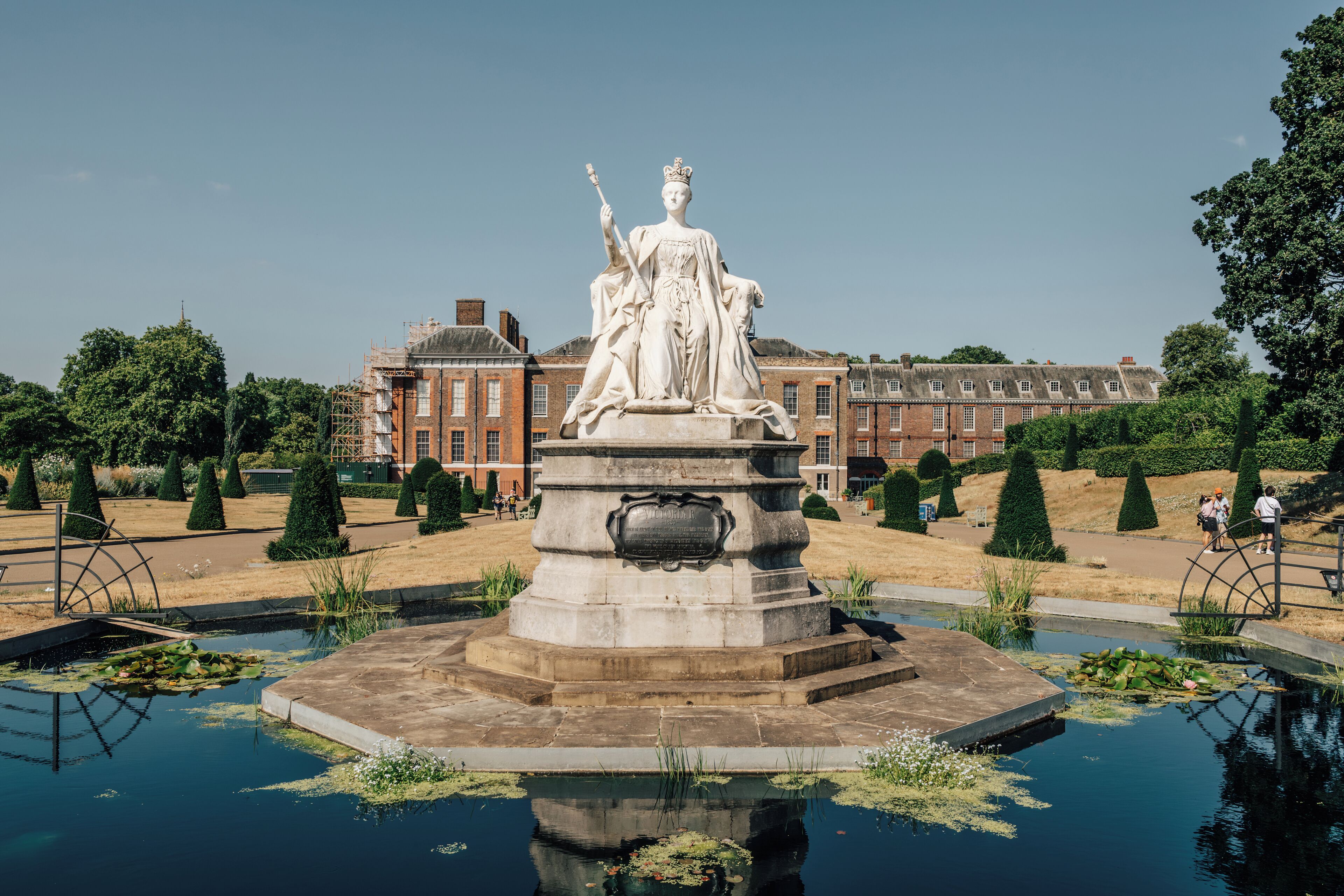 Une statue dans une fontaine, avec un bâtiment en arrière-plan.