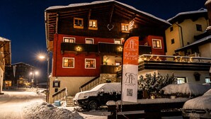 A multi-story building with a red facade, balconies, and a sign reading 'HAUS RICHARD FALCH'. - Haus Richard Falch – Chalet in St. Anton, 2 Min. to Galzigbahn (Sankt Anton am Arlberg)