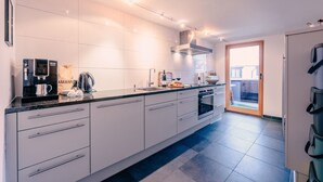 A modern kitchen with a built-in coffee machine, a kettle, and a wine glass on the counter. - Haus Richard Falch – Chalet in St. Anton, 2 Min. to Galzigbahn (Sankt Anton am Arlberg)