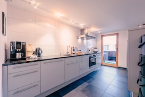 A modern kitchen with a built-in coffee machine, a kettle, and a wine glass on the counter. - Haus Richard Falch – Chalet in St. Anton, 2 Min. to Galzigbahn (Sankt Anton am Arlberg)
