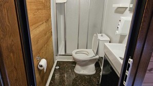A bathroom with a toilet, shower, and sink. - hevas suite (çalmlıhemşin)
