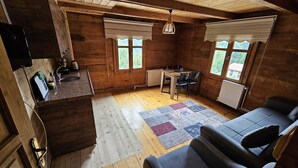 A cozy cabin interior with a kitchen, dining area, and seating space. - hevas suite (çalmlıhemşin)