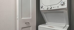 A white washing machine with control knobs and a door. - 2-bedroom condo in beautiful McCall with Indoor pool, hot tub and fitness room (McCall)