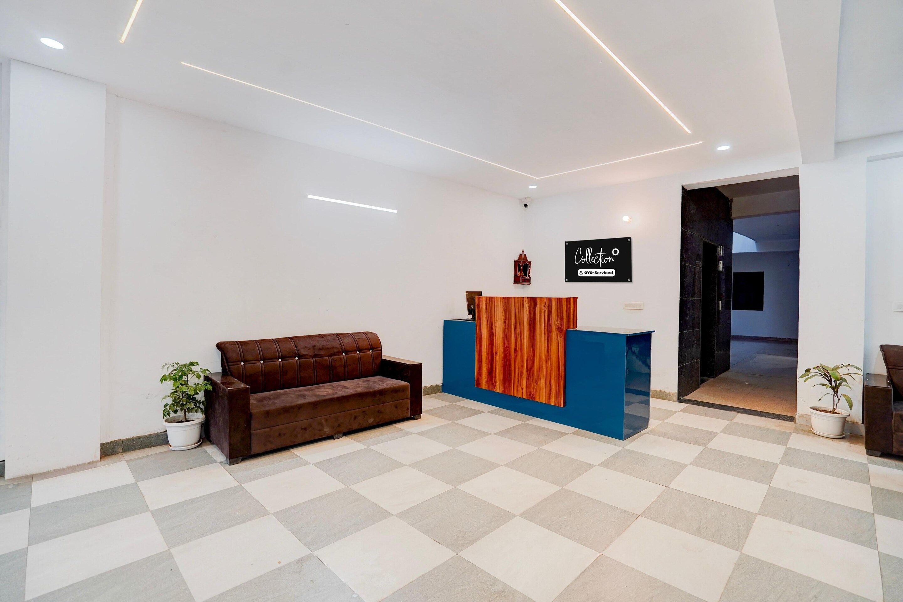 A reception area with a brown sofa, a blue reception desk, and a sign that reads 'Collection OYO-Service.'