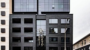 Ein modernes Gebäude mit Glasfassade und zahlreichen Fenstern, mit einem Schild, auf dem 'TOKYO' steht.