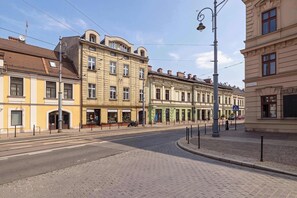 A street with buildings, a pedestrian crossing, and a clear sky. - Functional Studio with a Mezzanine | Podolski Boulevard  AC (Kraków)
