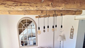Een woonkamer met een bank, fauteuils, een salontafel en hanglampen.