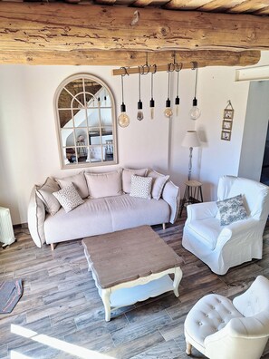 A living room with a sofa, armchairs, a coffee table, and hanging light fixtures. - Provençal house near Uzès with a garden and 2 air-conditioned bedrooms (Le Pin)