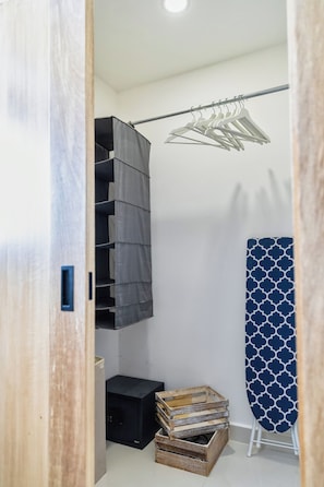 A compact room with a built-in wardrobe, a drying rack, and a small wooden crate. - Luxury Pool Condo Near Beach & Downtown (Punta Cana)