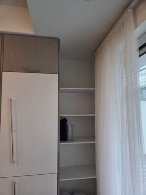 A room with a wardrobe, a shelf unit, and a window with curtains. - Cozy 1-bedroom apartment with AC steps to attractions in downtown Toronto (Toronto)
