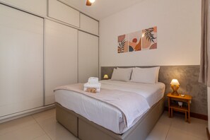 Ein Schlafzimmer mit einem Bett, Nachttischen, einem Kleiderschrank und Bildern an der Wand.