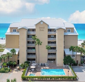 A hotel with a pool, palm trees, and a view of the beach. - Remodeled Beachfront-Amazing Location! 
Gated Community. (Destin)