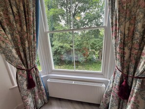 A room with a window, curtains, and a radiator. - Bluebell Suite at Elmwood House (Nottingham)