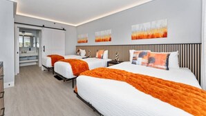 Une chambre d’hôtel avec deux lits, une porte coulissante et une vue sur l’extérieur.