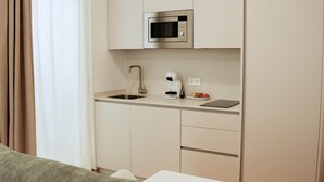 A compact kitchenette with a built-in microwave, a coffee maker, and a small sink. - Olea Suites Conil · 4 (Conil de la Frontera)