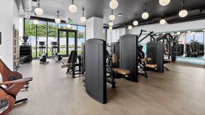 Ett modernt gym med olika träningsmaskiner, stora fönster och en ren och rymlig inredning.