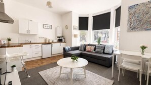 Een moderne woonkamer met een bank, salontafel en een eethoek.