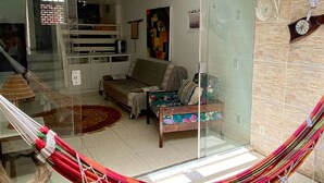 Un saló amb un hamaca, un sofà, una taula de centre i un quadre al mur.