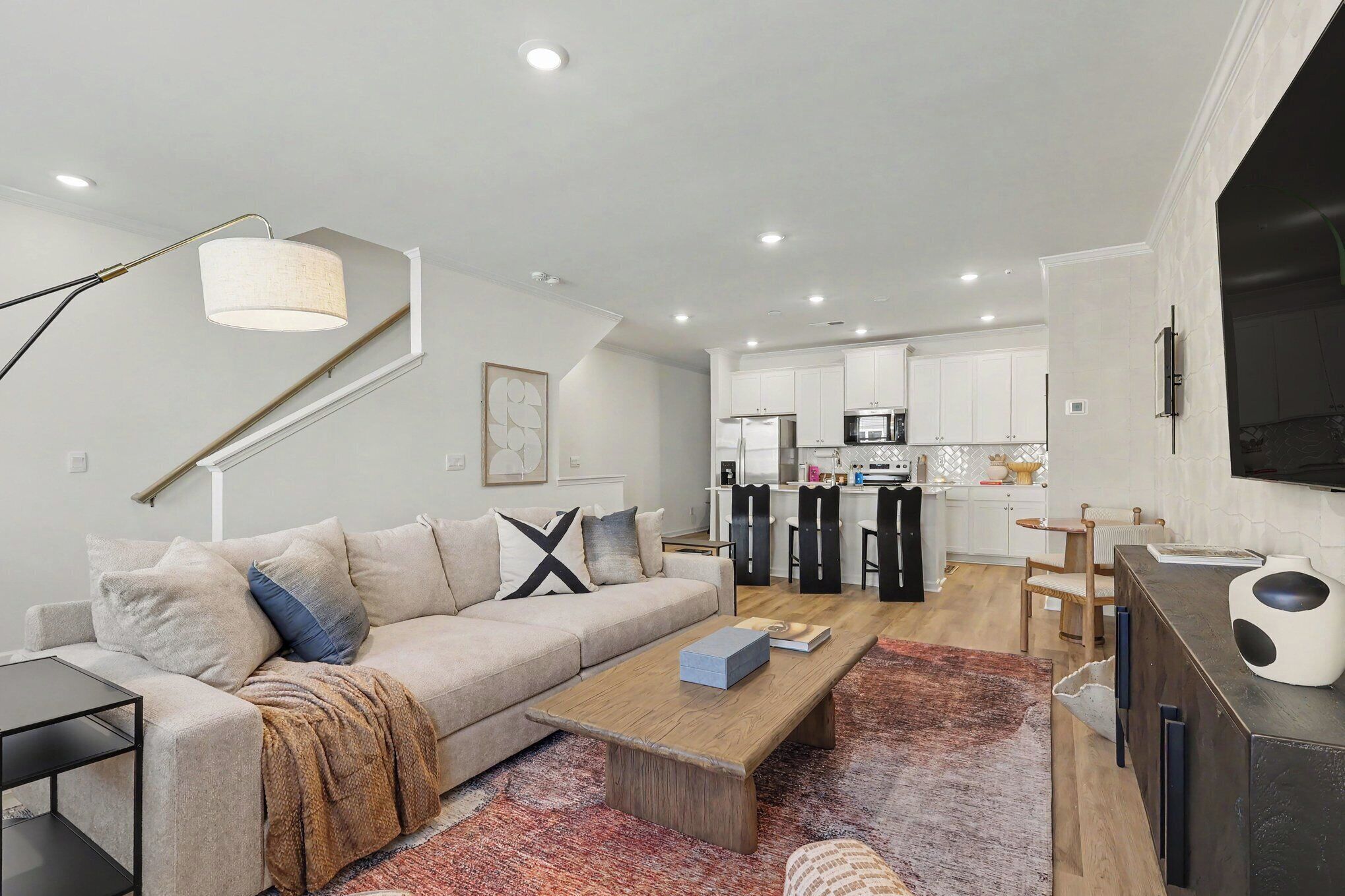 A modern living room with a sofa, coffee table, and a TV stand.