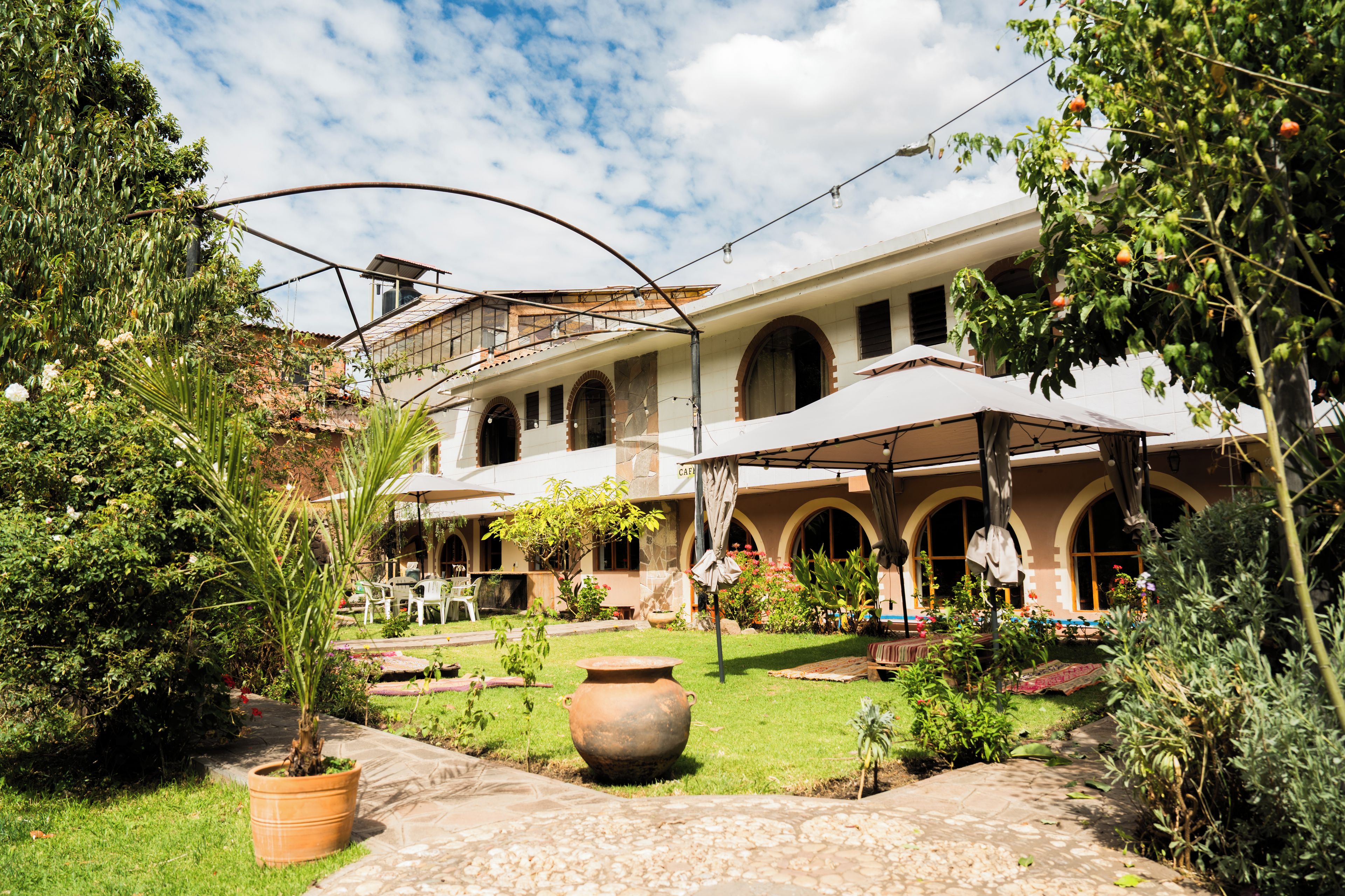 Un patio con un edificio que tiene ventanas de arco y un área de patio techada.