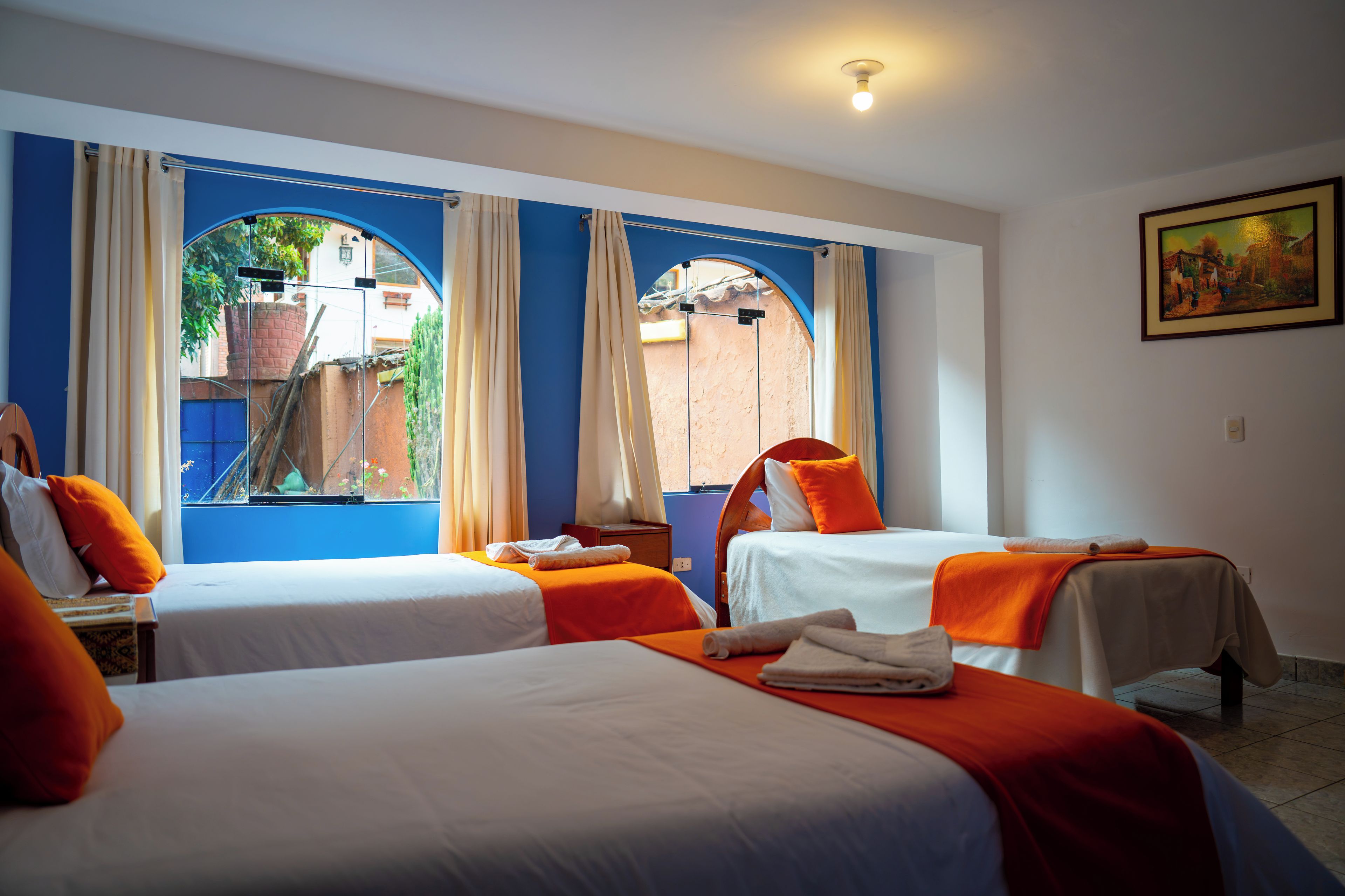 Habitación de hotel con dos camas, un cuadro en la pared y vistas por la ventana.