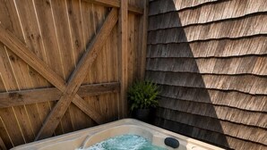 A hot tub with a control panel, surrounded by wooden decking and a wooden fence. - Walk to Main Street, Hot tub, Fireplace! (Fredericksburg)