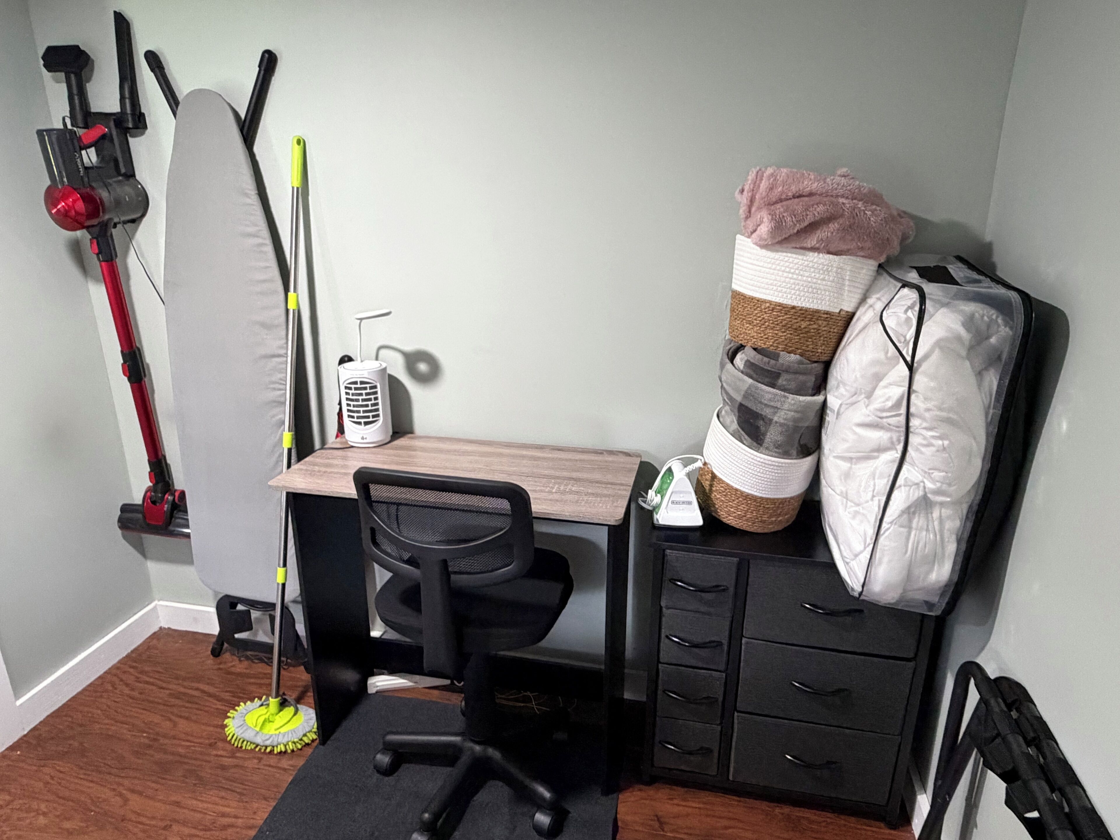 Un espace de bureau compact comprenant un bureau, une chaise et des tiroirs de rangement.