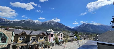 En stad med byggnader längs en gata, ett berg i bakgrunden och en klar himmel.