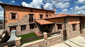 Un edificio de piedra con varias habitaciones, un patio y cielo despejado.