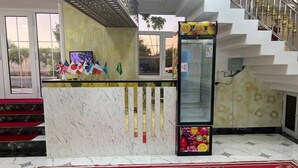 A reception area with a marble counter, a red carpet, and a staircase. - ALIMOV Guest House (Samarkand)