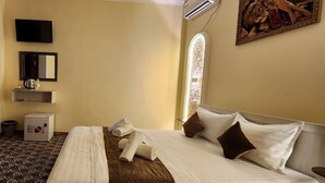 A hotel room with a bed, a television, a mirror, a window, and a painting. - ALIMOV Guest House (Samarkand)