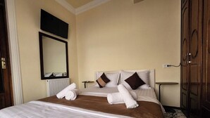 A hotel room with a large bed, a bedside table, a mirror, and a wardrobe. - ALIMOV Guest House (Samarkand)