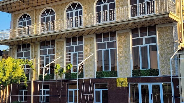 A multi-story building with a balcony, large windows, and a staircase. - ALIMOV Guest House (Samarkand)