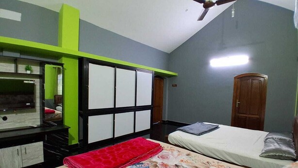 Une chambre à coucher comprenant un lit, un bureau, une chaise, une armoire et un ventilateur de plafond.