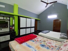 Un dormitorio con cama, escritorio, silla, armario y ventilador de techo.