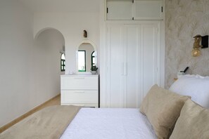 A bedroom with a bed, a dresser, a wardrobe, and a mirror. - Beverly Hills Bungalow (San Bartolomé de Tirajana)