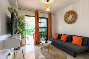 A living room with a sofa, TV, and plants. - Beverly Hills Bungalow (San Bartolomé de Tirajana)