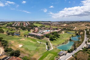 A golf course with multiple holes, a clubhouse, and a swimming pool. - Boavista Lakeview Golf Pool Retreat (Lagos)