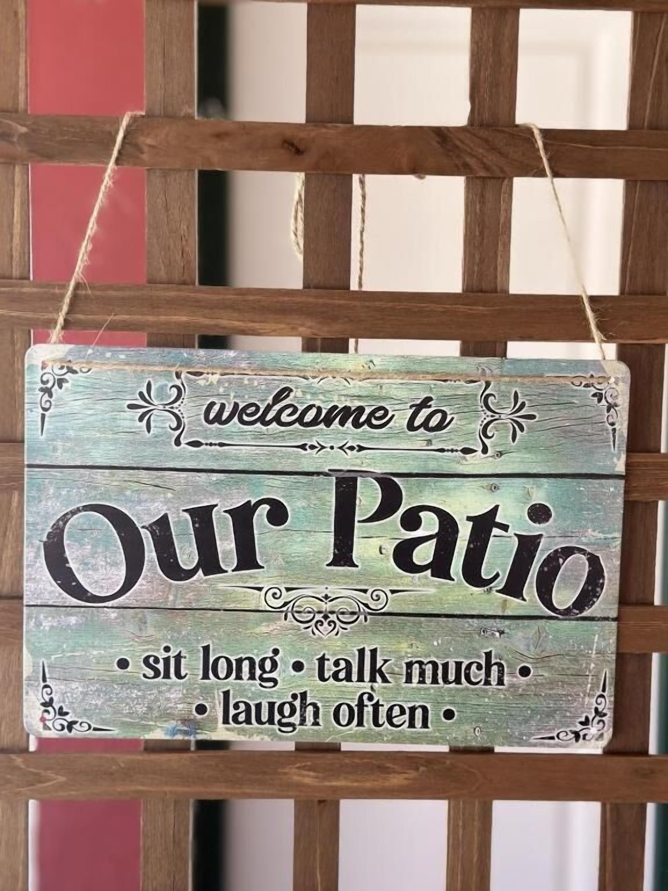 A rustic wooden sign with the text 'welcome to Our Patio' and a list of activities.